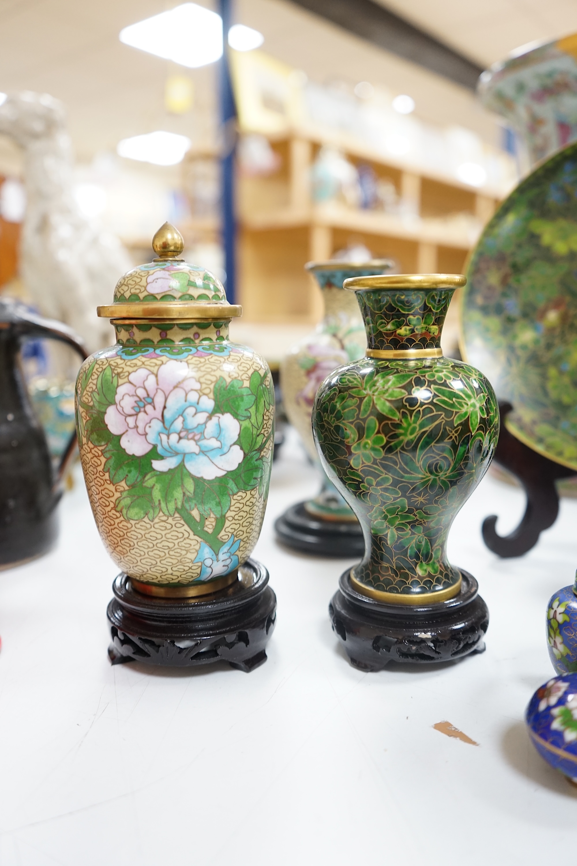 A collection of Chinese cloisonné enamel wares, with mixed coloured backgrounds, all with floral designs, some with stands, plate 21cm diameter. Condition - good